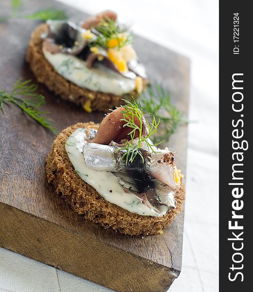 Anchovy canapes garnished with dill and yolk