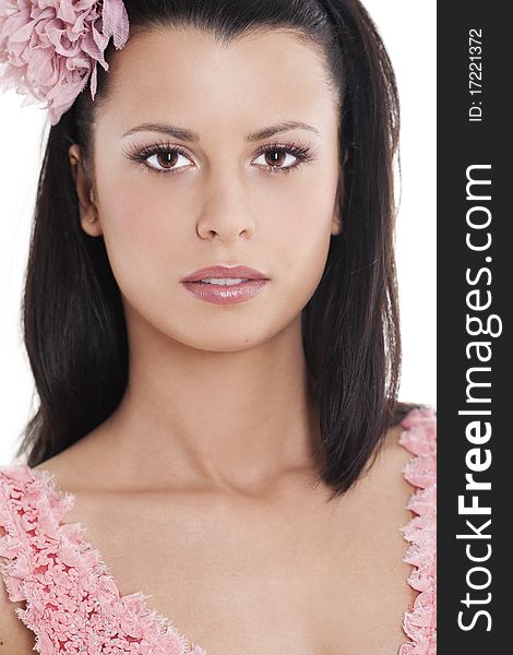 Portrait of young woman in pink dress smiling against white background