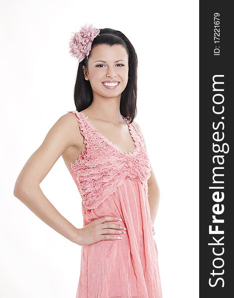 Portrait of young woman in pink dress smiling against white background