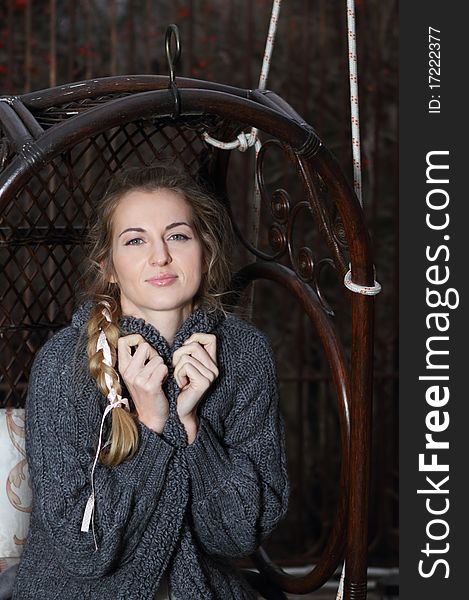 Beautiful blond girl with plait on the swing