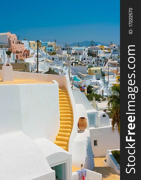 Landscape of city Fira with traditional houses on island of Santorini, Greece. Big yellow staircase in center of white building. Landscape of city Fira with traditional houses on island of Santorini, Greece. Big yellow staircase in center of white building.