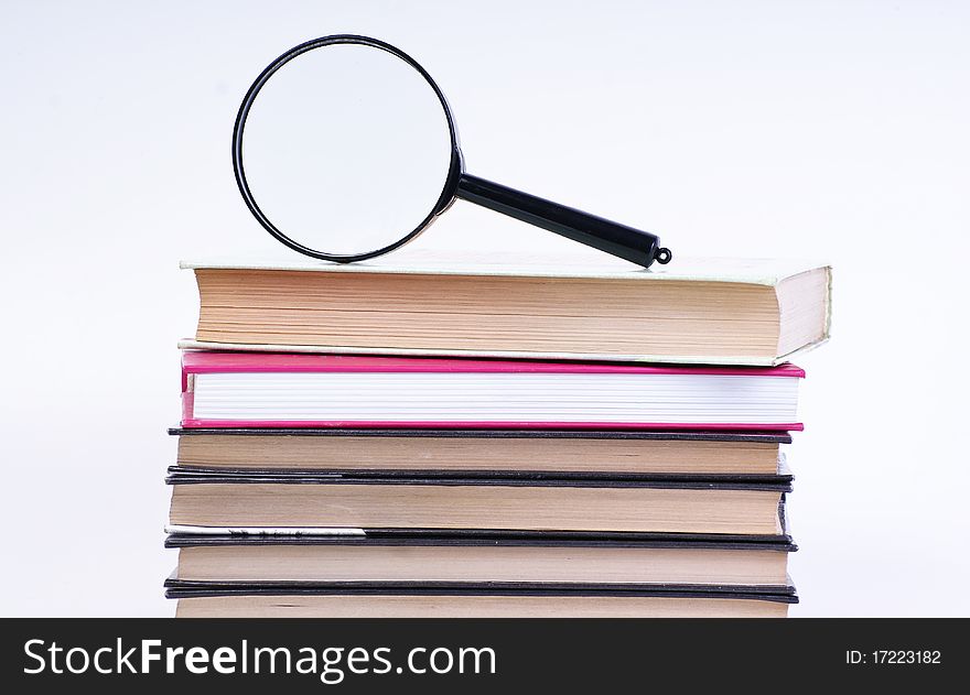 Book with magnifying glass on white background