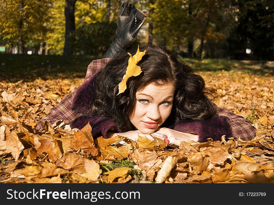 Pretty glamour girl lays on the fallen leaves. Pretty glamour girl lays on the fallen leaves