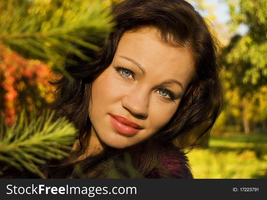 Pretty young woman smiles on the background of autumn trees. Pretty young woman smiles on the background of autumn trees