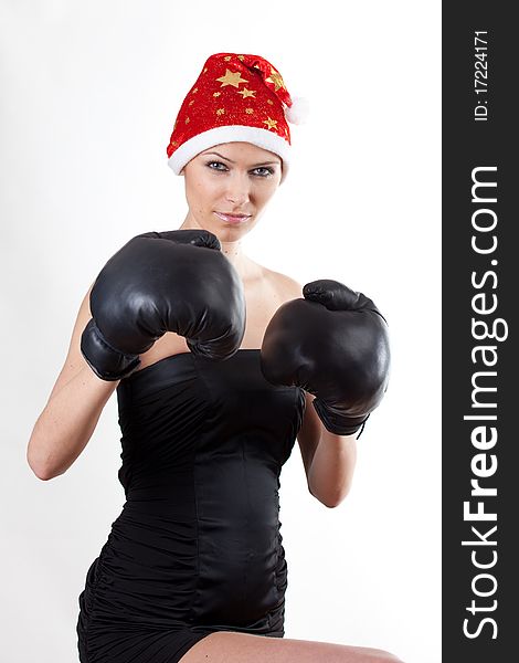 Young girl in Santa Claus hat with boxing gloves. Young girl in Santa Claus hat with boxing gloves