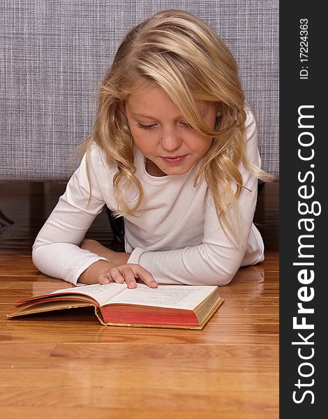 Girl reading a book on the floor