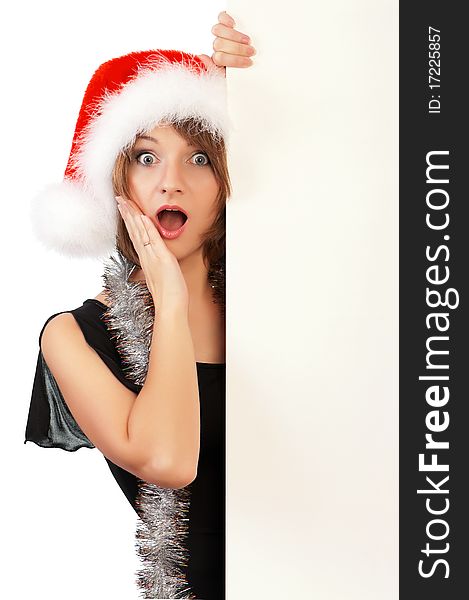 Emotional beautiful christmas girl wearing Santa hat, holding a white blank. Isolated on white background.