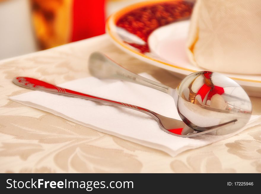 Formal dining table setup and reflection on spoon. Formal dining table setup and reflection on spoon