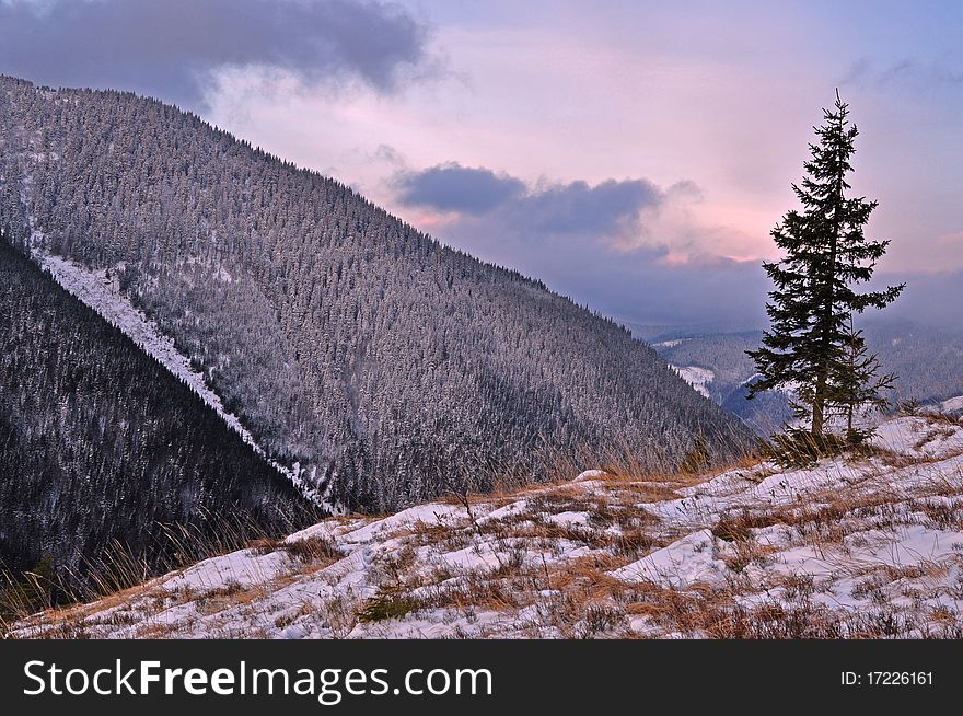 A dawn in a winter mountain landscape with clouds. A dawn in a winter mountain landscape with clouds.