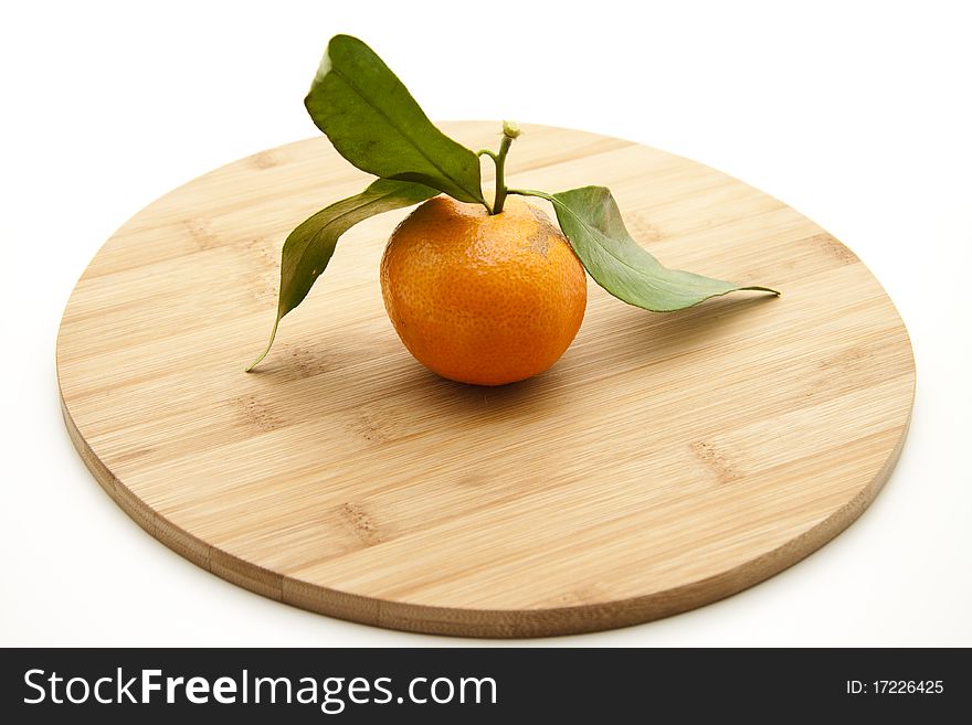 Tangerine with leaf onto wood plates