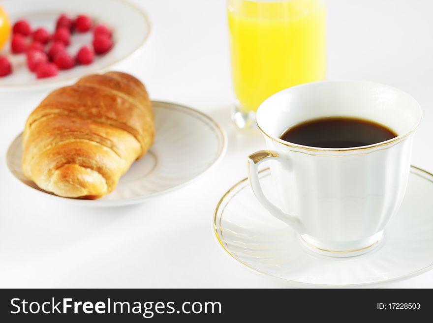 Breakfast. A cup of coffee, croissant, orange juice and berries. Breakfast. A cup of coffee, croissant, orange juice and berries