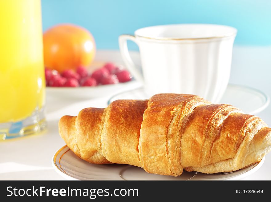 Breakfast. A cup of coffee, croissant, orange juice and berries. Breakfast. A cup of coffee, croissant, orange juice and berries