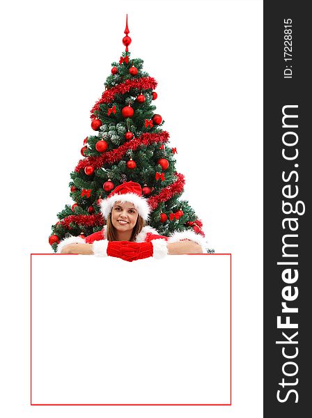 female Santa with red hat and gloves, before the Christmas tree, over a white billboard for your text. female Santa with red hat and gloves, before the Christmas tree, over a white billboard for your text