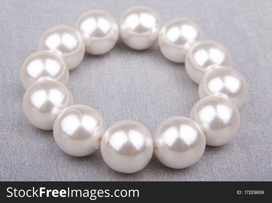 Pearl bracelet against a silvery organza