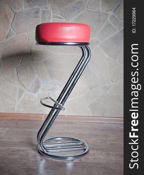 Club metal chair in red on a background of stone