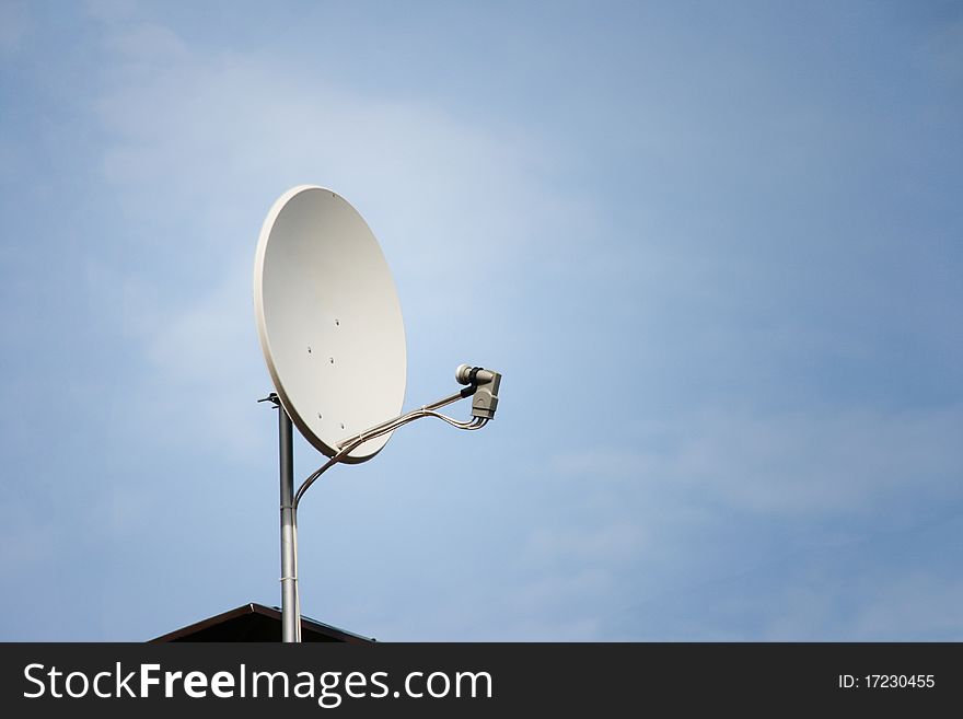 Satellite dish on roof against the blue sky