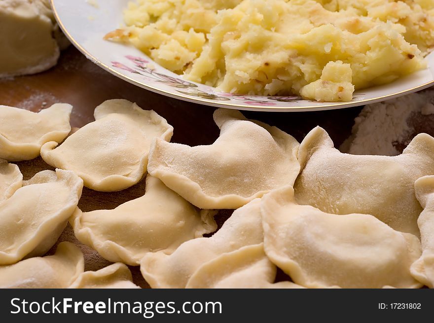 Traditional Ukrainian domestic dumplings filled with potatoes on the table closeup