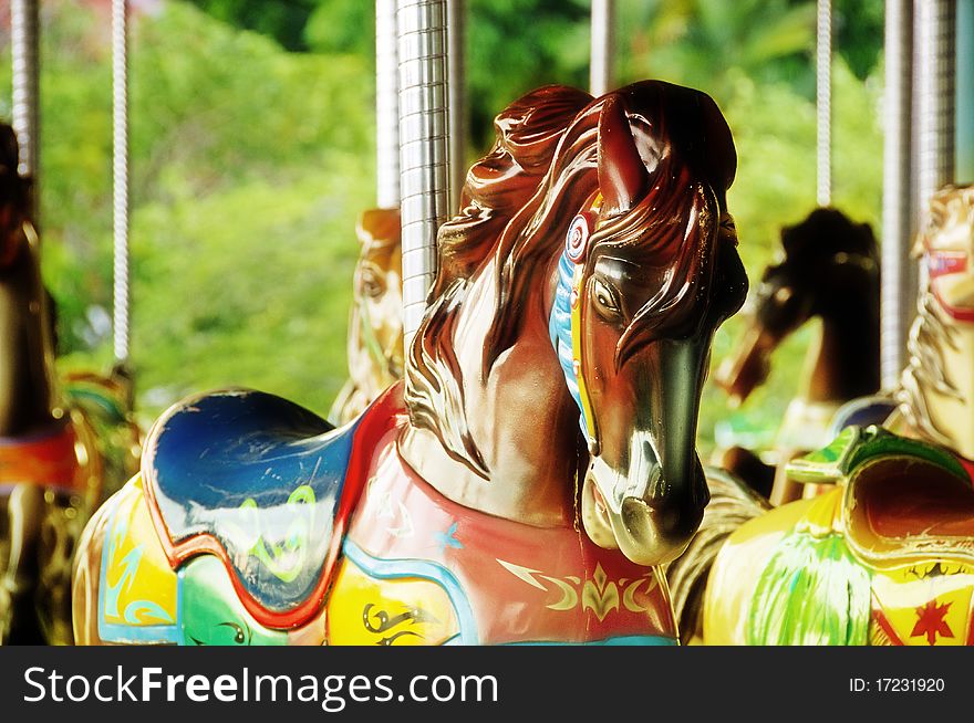 Horses of carousel in the amusement park