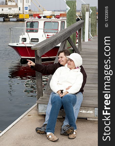 View of a happy couple in vacation or spending free time at a pier.