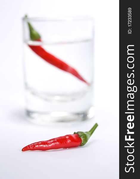 Red pepper against with a vodka wine-glass