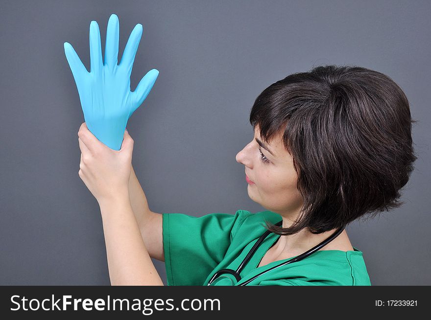 Doctor putting on blue sterilized medical glove for making operation