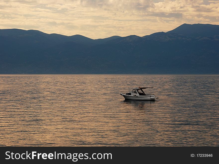 Sunrise And A Lonely Boat On The Sea