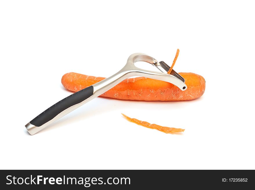 A carrot peeler and carrots isolated on a white background. A carrot peeler and carrots isolated on a white background.