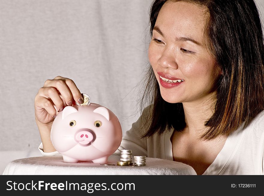 Young woman with pink piggy bank