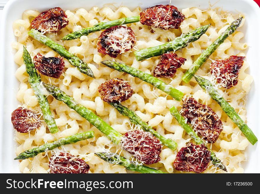 Pasta baked with dried tomatoes, asparagus and pecorino cheese. Pasta baked with dried tomatoes, asparagus and pecorino cheese
