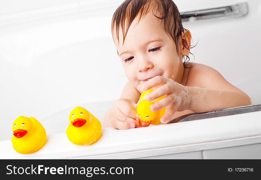 Beautiful little boy taking a relaxing bath and playing with toy ducks. Beautiful little boy taking a relaxing bath and playing with toy ducks