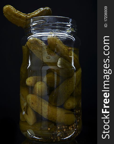 Cucumber vegetables canned in glass jars. Photo.