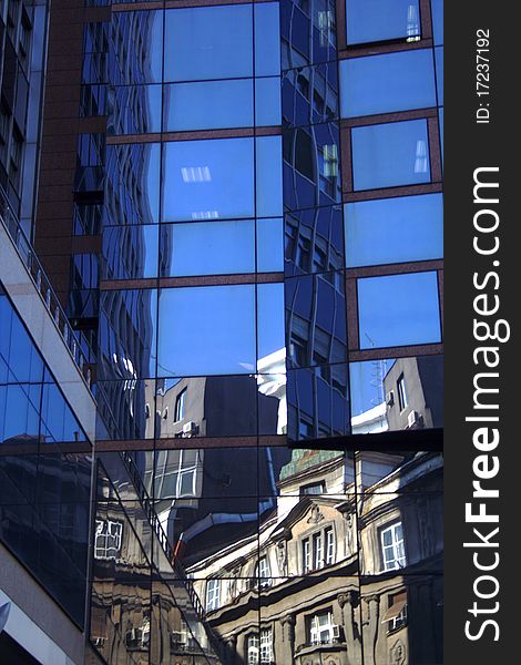 Old buildings reflecting and distorting in the windows of a modern building. Old buildings reflecting and distorting in the windows of a modern building.