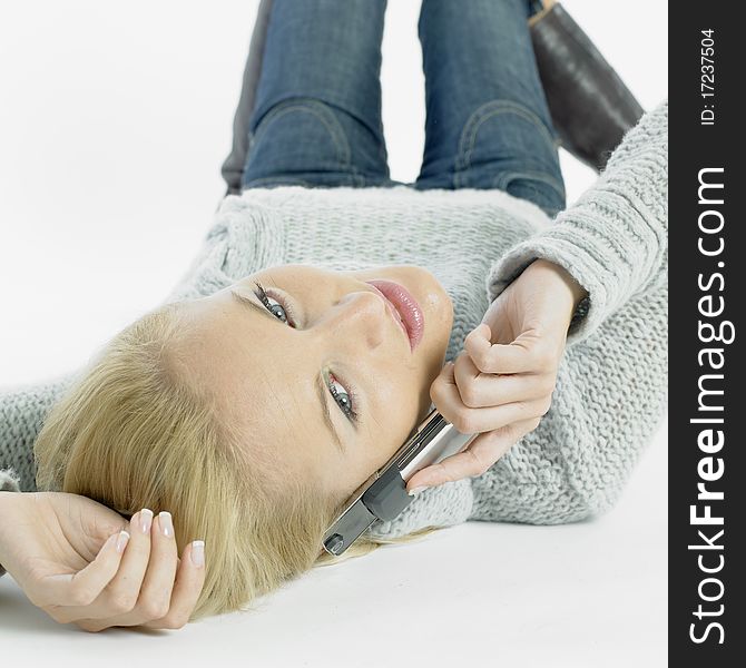 Calling young woman lying on the floor. Calling young woman lying on the floor