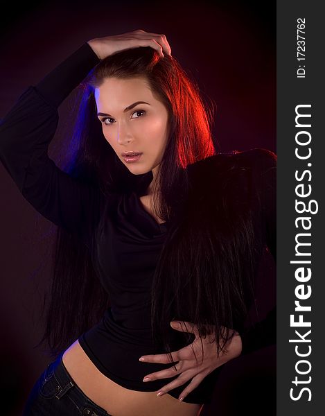 Portrait of beautiful young woman over dark background