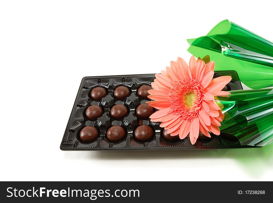 Ñhocolates with a flower are isolated on a white background