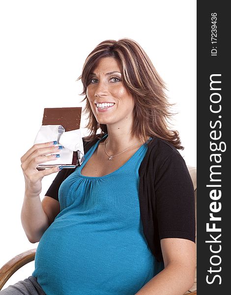 A pregnant woman sitting and enjoying a big candy bar with a happy expression on her face. A pregnant woman sitting and enjoying a big candy bar with a happy expression on her face.