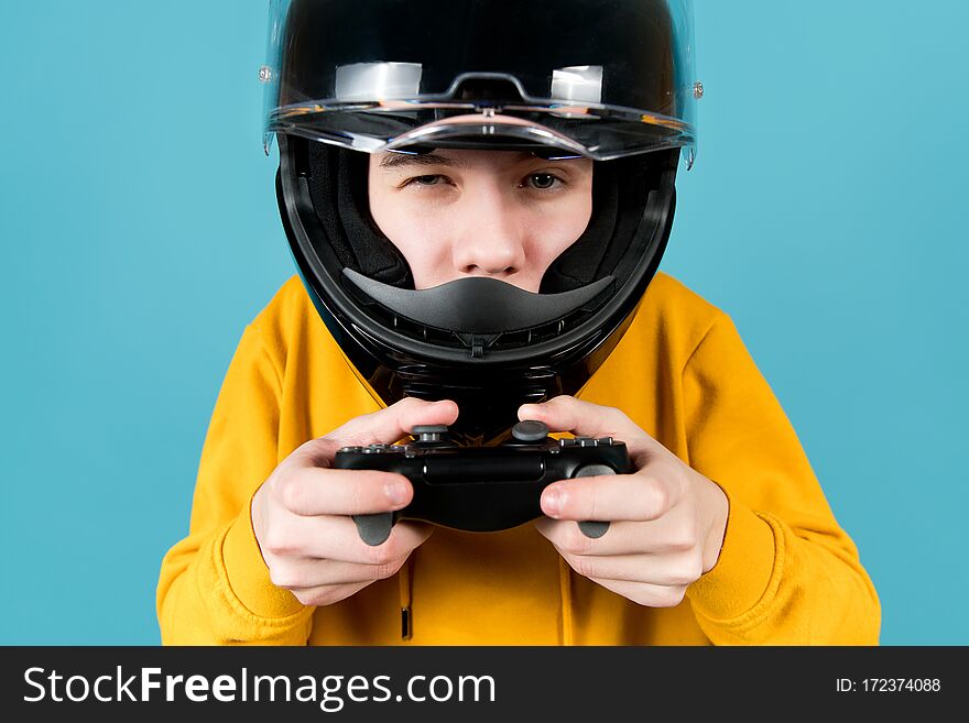 Close-up Of A Teenager In A Black Motorcycle Helmet And With A Joystick In His Hands