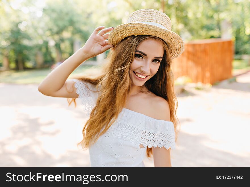 Close-up Portrait Of Inspired Young Lady With Beautiful Eyes Holding Straw Hat. Romantic Fair-haired Girl With Pale Skin