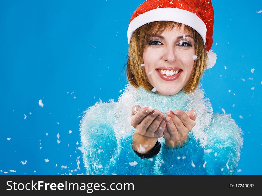 Lovely girl catch the snow at Christmas time, blue background