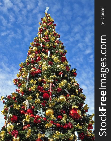 Very colorful christmas tree on a blue sky background. Very colorful christmas tree on a blue sky background