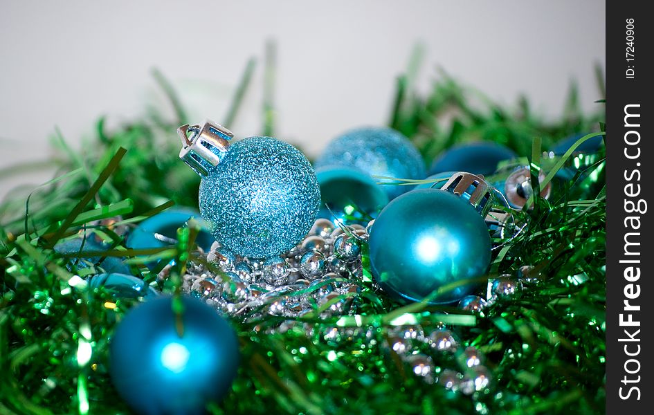 Blue and green Christmas balls laying on the table, white background. Blue and green Christmas balls laying on the table, white background