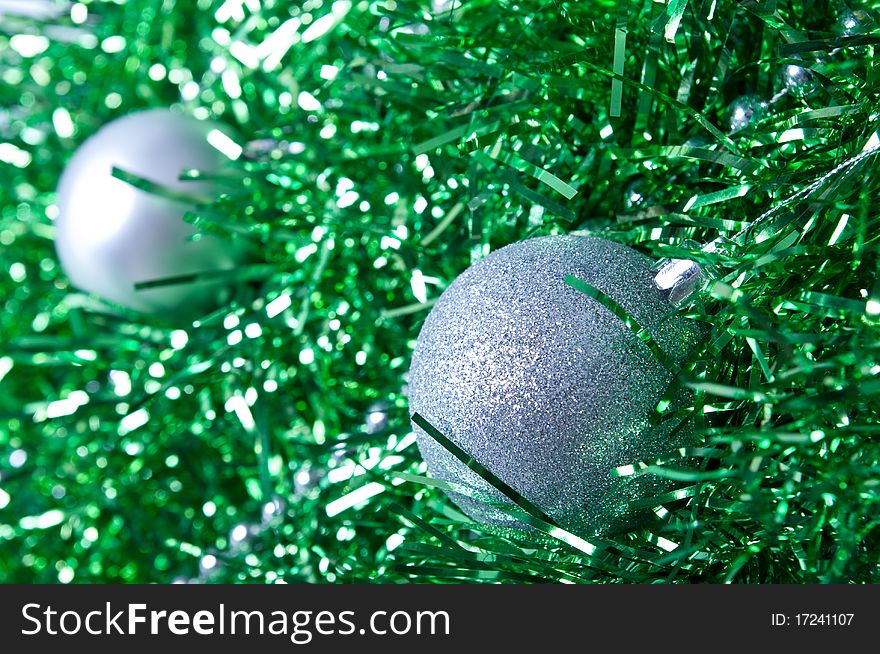 Silver Christmas ball lying on a green decor. Silver Christmas ball lying on a green decor