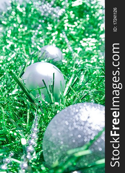 Silver Christmas ball lying on a green decor. Silver Christmas ball lying on a green decor