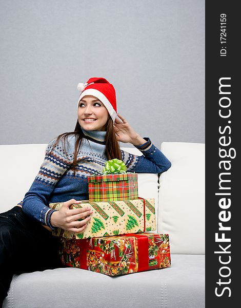 Pretty caucasian girl in santa hat with gifts