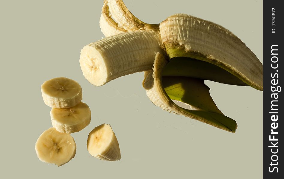 A banana peeled and partly sliced.