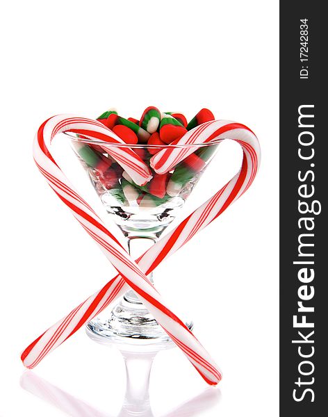 Martini Glass with christmas and new year candies, heart of candy canes isolated on a white background. Martini Glass with christmas and new year candies, heart of candy canes isolated on a white background