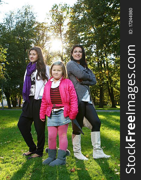 Young family taking healthy stroll through autumn park and have fun. Young family taking healthy stroll through autumn park and have fun