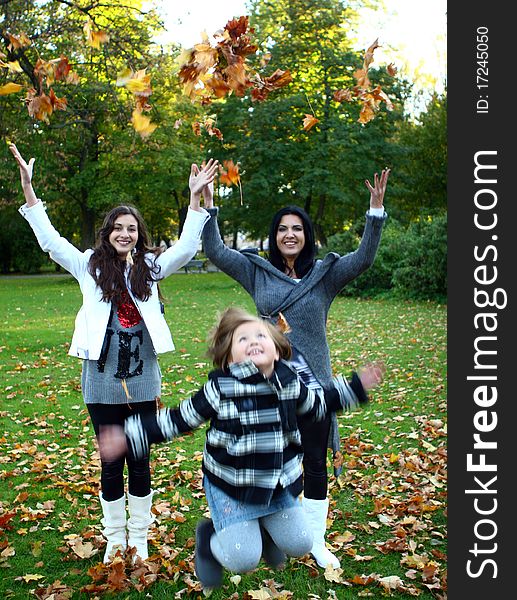 Young family taking healthy stroll through autumn park and have fun. Young family taking healthy stroll through autumn park and have fun