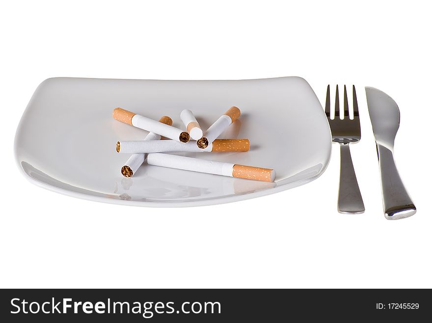 Several cigarettes on the plate with fork and knife. Several cigarettes on the plate with fork and knife