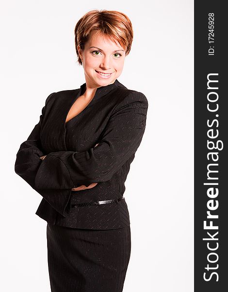 Beautiful businesswoman with her arms crossed on light grey background